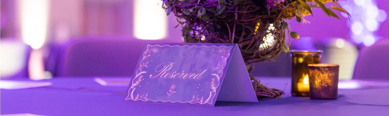 A paper sign that says "reserved" in a gold cursive font